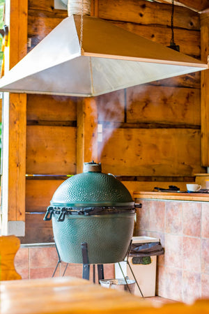 A giant buffet of grilled meats and other foods on an outdoor wooden table made on a Big Green Egg Grill.