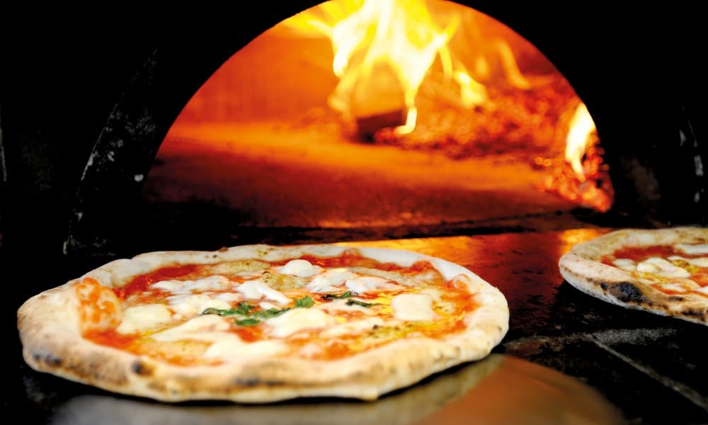 Freshly cooked pizza coming out of an Alfa pizza oven